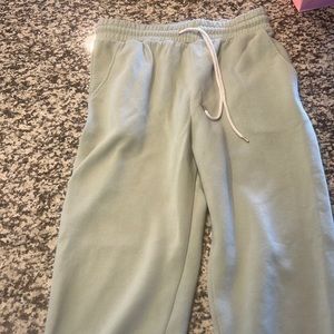 Light green sweatpants, cuffed at the bottom.
